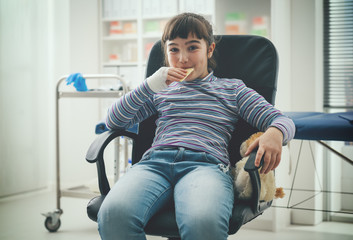 Cute girl eating a snack in the doctor's office