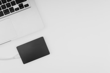 Laptop keyboard, storage drive or hard disk on yellow background with selective focus, crop fragment, business, backup, copy space concept. Black and White