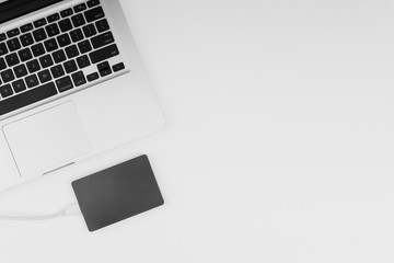 Laptop keyboard, storage drive or hard disk on yellow background with selective focus, crop fragment, business, backup, copy space concept. Black and White