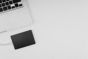 Laptop keyboard, storage drive or hard disk on yellow background with selective focus, crop fragment, business, backup, copy space concept. Black and White