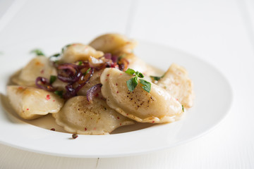 Dumplings, pelmeni, pierogi, with fried onions