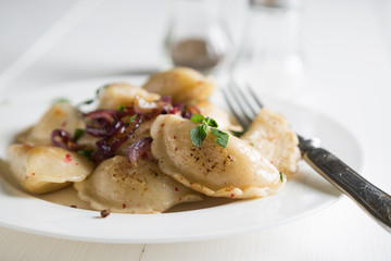 Dumplings, pelmeni, pierogi, with fried onions