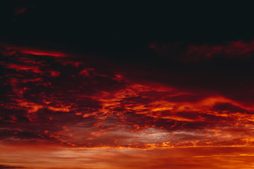 Fiery red blood vampire dawn. Amazing warm dramatic fire cloudy sky. Vivid orange sunlight....