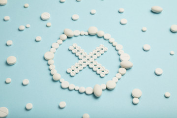 Stop symbol made of white pills on blue background. Medical care, ambulance.