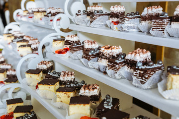 Delicious candy bar at the wedding reception. Chocolate cakes and muffins.Sweet red hearts. Desserts for guests.