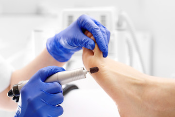 Milling pedicure. The beautician is filing the calluses on the foot