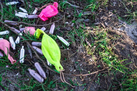 metal bulb and balloons for  laughing gas, party drugs, on grass field