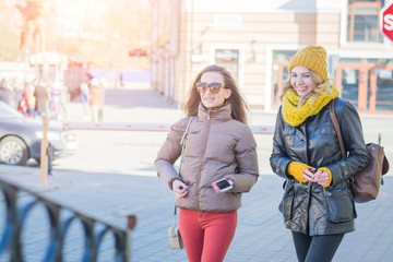 Outdoor portrait of two female friends walking city street