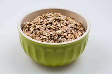 Bowl with dried oats close up isolated on white