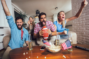 Friends cheering sport league together on tv and celebrating victory at home.Friendship, sports and entertainment concept. - obrazy, fototapety, plakaty
