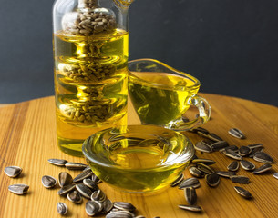 sunflowers and sunflower oil with seeds on on a wooden table. Bio and organic concept of the...