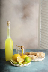 Bottle of homemade juice with ginger and lemon on light background. Vertical