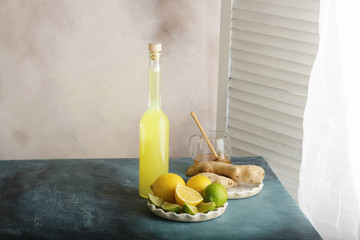 Bottle of homemade juice with ginger and lemon on light background. Horizontal