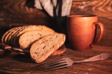Rural still life with homemade bread on rustic background inthe morning light