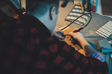 An artist using wood. Handmade use of a drill