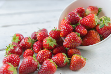 Strawberries heap on white table.