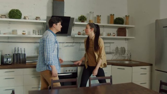 Married couple during domestic swearing, jealous man starting conflict, pushing woman, insulting, accusing of treason, demanding explanations. Offended by baseless accusations wife slapping husband.