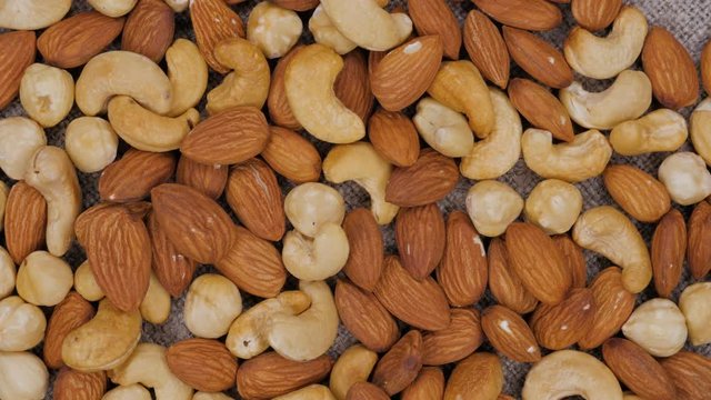 Rotating background of nuts mix. Cashew. Hazelnut. Almond. Assorted nuts.