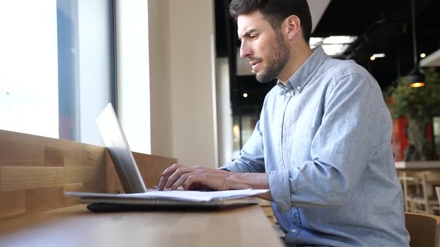 Relaxed businessman working in caf&eacute; after meeting