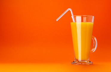 Glass of orange juice isolated on colour orange background with copy space for text, fresh citrus cocktail