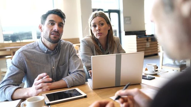 Diverse sales team prepping meeting in modern office space