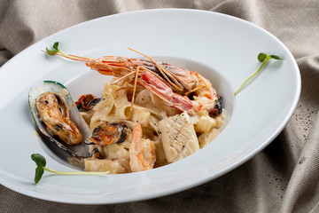 Tagliatelle with seafood on textile background
