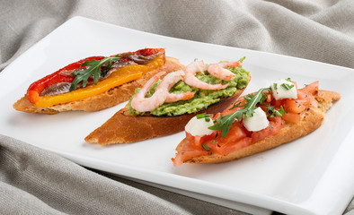 Brushetta snacks for wine. Variety of small sandwiches on a textile background