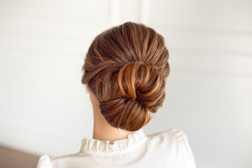 Rear view of female hairstyle medium bun with dark hair.