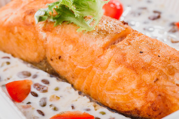 Serving a dish Salmon fillet in a creamy sauce 