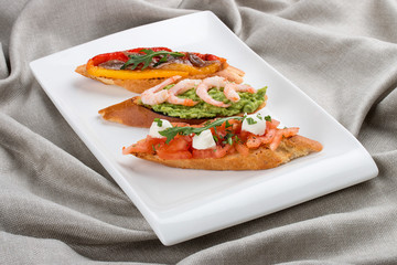 Brushetta snacks for wine. Variety of small sandwiches on a textile background
