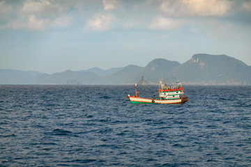 White Fishing boat heading out to the ocean in the early morning