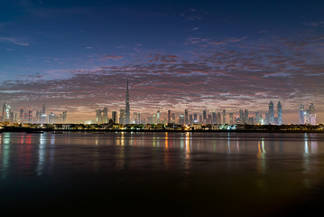 Fototapeta premium Poranek, wschód słońca lub zmierzch w Dubaju. Świt nad Burj Khalifa. Piękne kolorowe pochmurne niebo nad centrum Dubaju. Blask budynków lub drapaczy chmur