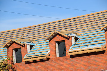 Construction of the roof of a new house. Wooden bars and vapor barrier