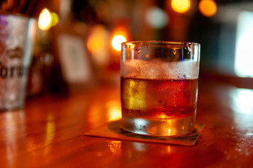 バーでウィスキーグラスを傾ける