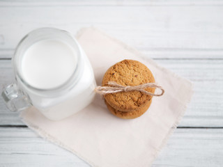 Milk and cookies on a wooden white table