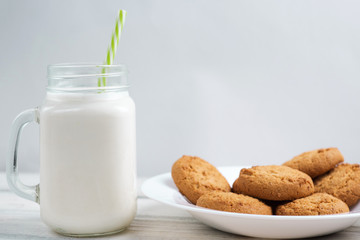 Milk and cookies on a wooden white table