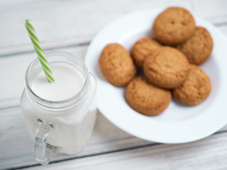 Milk and cookies on a wooden white table