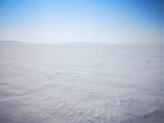 View of a large frozen lake in an empty winter landscape in Russia