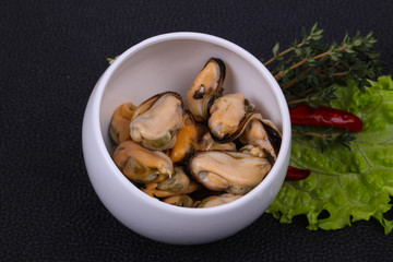 Pickled mussels in the bowl served pepper, garlic and salad