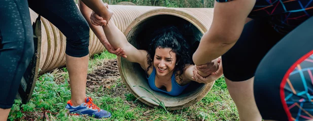 Foto op Canvas Female participants in an obstacle course going through a pipe © David Pereiras