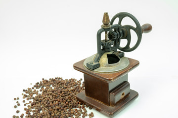 Vintage rusty, wooden black pepper grinder or mill with a mechanical handle  gear and scattered...