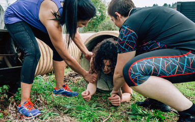 Female participants in an obstacle course going through a pipe