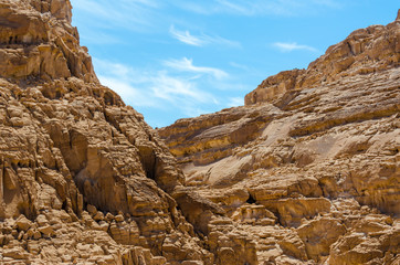 Fototapeta na wymiar high rocky mountains against the blue sky and white clouds in the desert in Egypt Dahab South Sinai