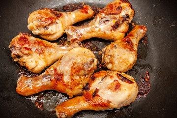 Roasted chicken legs on the black background. Top view.