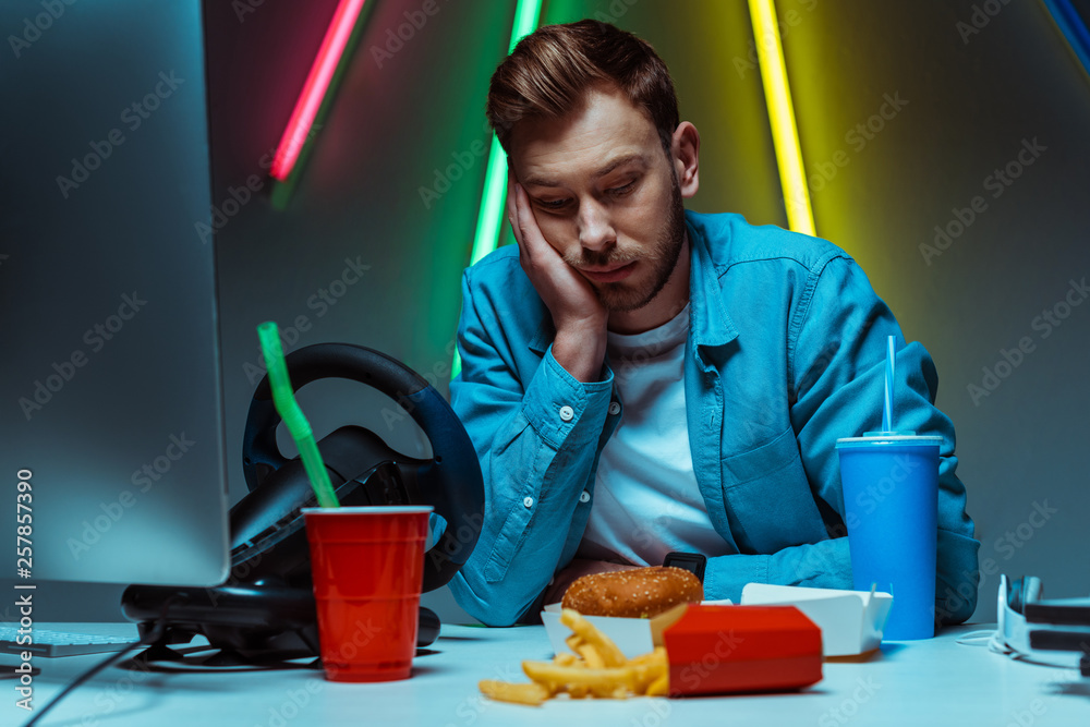 Wall mural handsome and sad man touching his head and looking down