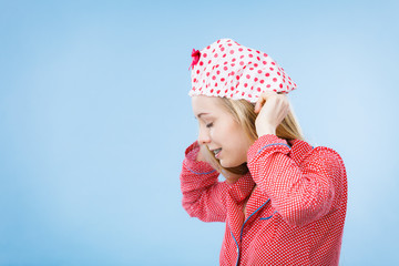 Young woman wearing pink pajamas putting bathing cap