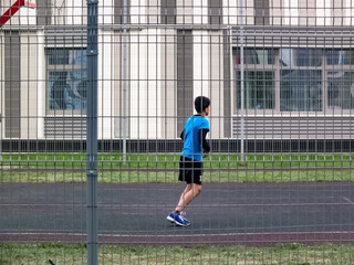 The boy runs on the playground in the yard