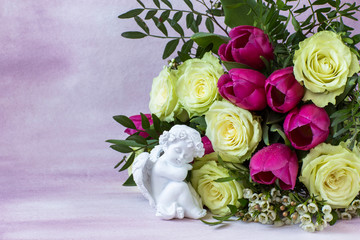 on a pink background, a bouquet of white roses and pink tulips and and a white angel