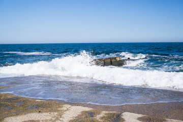 Sea waves on the beach, bright blue water