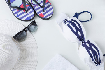 beach items with straw hat,  flip flops,  towel and sunglasses , top view. Vacation concept with marine theme 